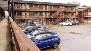 A multi-story building with a parking lot in front. - The Driftwood Lodge (Juneau)