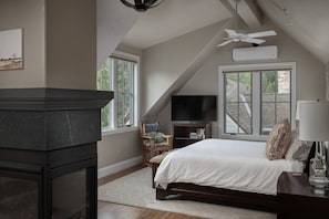 A bedroom with a bed, a television, a fireplace, and a window with a view of a brick building. - South Oak Retreat - convenient luxury by gondola! (Telluride)