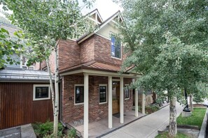 A two-story house with a brick exterior, a covered porch, and a garage. - South Oak Retreat - convenient luxury by gondola! (Telluride)