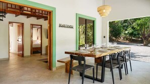 A dining area with a table set for four, a bench, and a sign reading 'BEACH TOWELS'. - Selva Blanca, Jungle Retreat (Playa Hermosa)