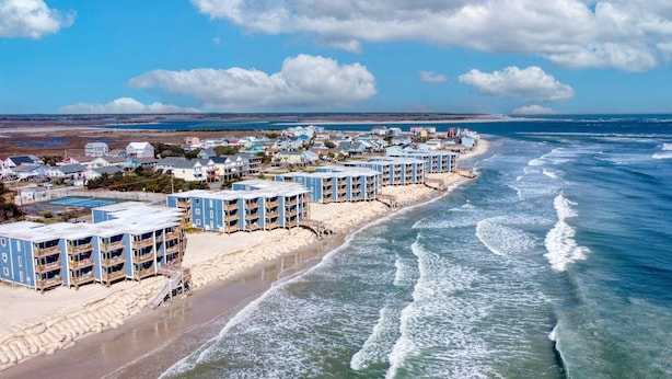 A coastal hotel with multiple blue buildings, a sandy beach, and ocean views. - Sun of a Beach- Your Ultimate Beachy Getaway (North Topsail Beach)
