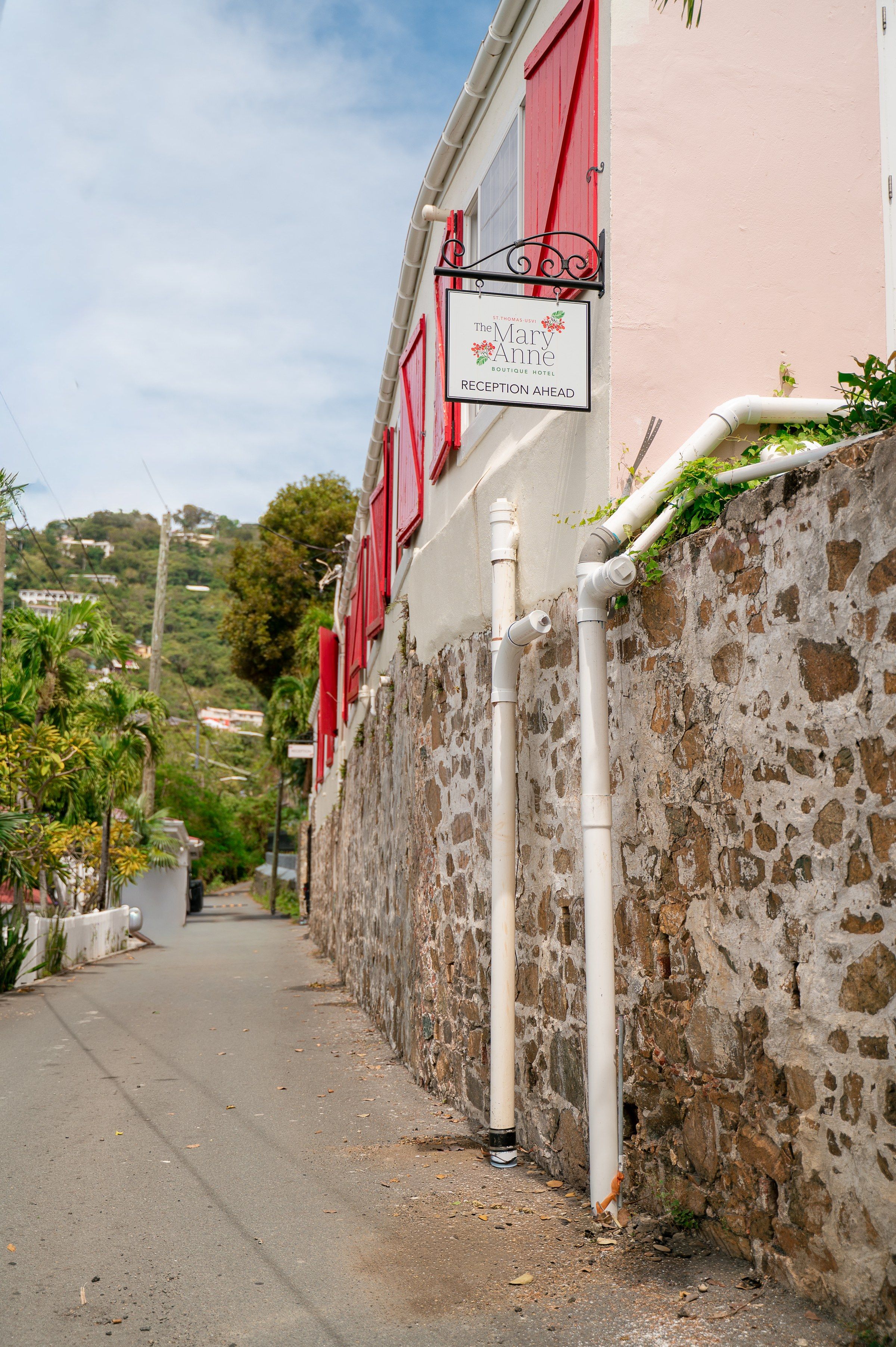A narrow street with a building featuring a reception sign.