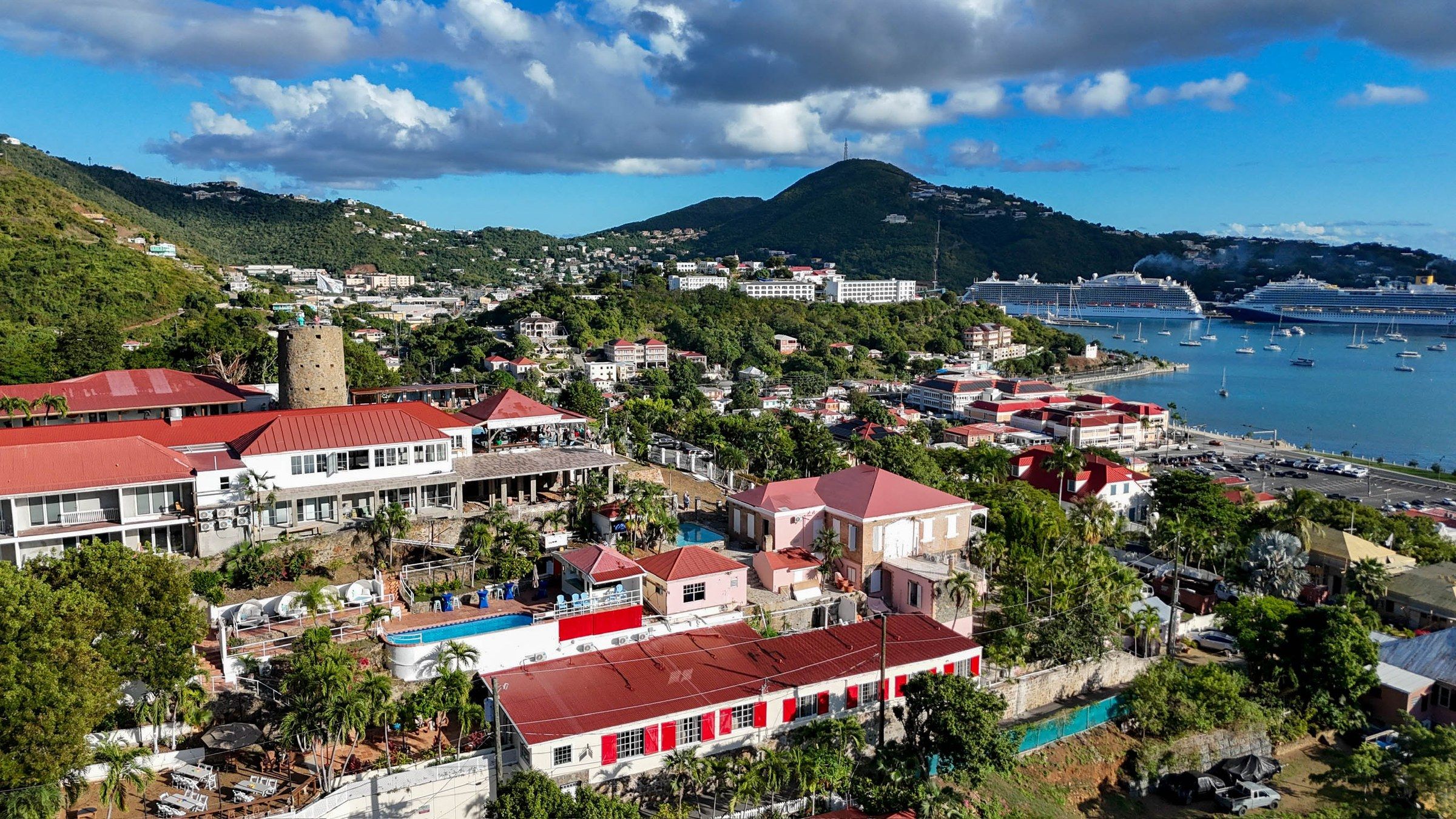 A coastal town with buildings, a swimming pool, and a view of the sea.