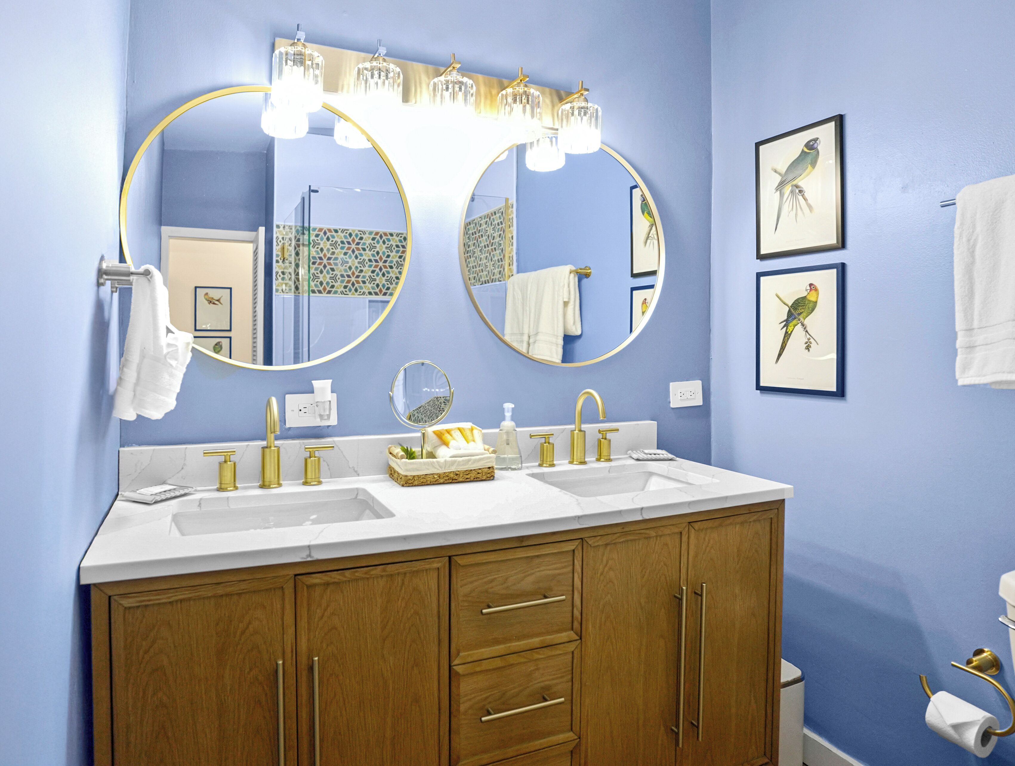 A bathroom with two sinks, a large mirror, and wooden cabinets.