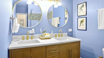 A bathroom with two sinks, a large mirror, and wooden cabinets.