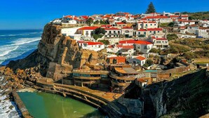A coastal village with buildings on a cliff, a sea wall, and a small pool. - Bright and Spacious Apartment in Porto (Porto)