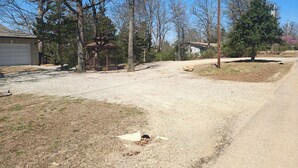 Un quartier résidentiel avec une allée en gravier, un belvédère et une maison dotée d’un garage.
