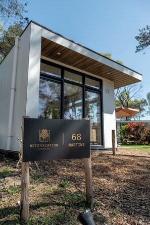 A modern building with a sign indicating 'METZ VACATION LODGES MARTINE 68'.