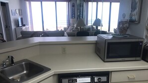 A kitchen with a sink, a microwave, and a dishwasher. - Oceanfront Sand Dollar Condo 601 (Daytona Beach Shores)