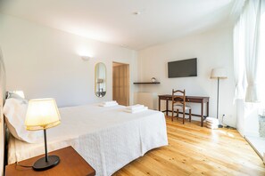 A hotel room with a bed, bedside table, desk, chair, TV, and a lamp. - Casa Da Brêa Viana do Castelo (Viana do Castelo)