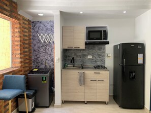 Eine kleine Küche mit Mikrowelle, Herd und Kühlschrank.