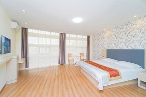 A hotel room with a large bed, wooden flooring, a modern headboard, a wall-mounted air conditioner, and a large window with curtains. - Yuntu Hotel (Shanghai Jinshan Bailian City Beach) (Shanghai)