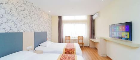A hotel room with two beds, a TV, a desk, and a window with curtains.