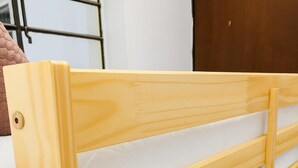 Una cama litera de madera con colchón y cabecera.