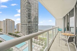 A balcony with a view of a swimming pool and high-rise buildings. - Emblematic unit at Icon in the heart of Brickell (Miami)