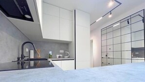 Eine moderne Küche mit glatter Arbeitsplatte, integriertem Herd und großem Fenster.