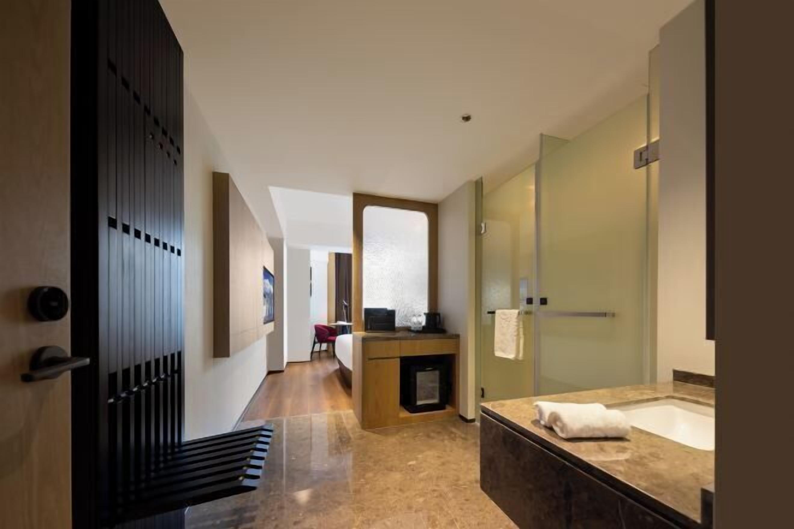A modern bathroom with a large mirror, a bathtub, and a vanity with a countertop.