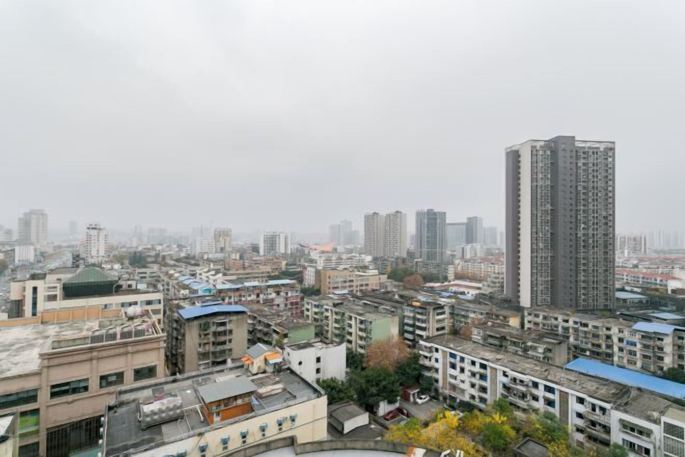 Un'area urbana densa con un mix di edifici alti e bassi, tra cui un edificio alto che spicca al centro.