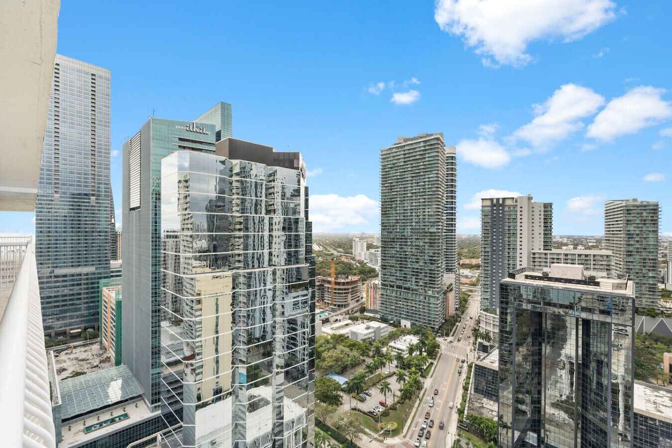 A high-rise urban area with modern skyscrapers, including a building with a glass facade and another with a unique angular design.