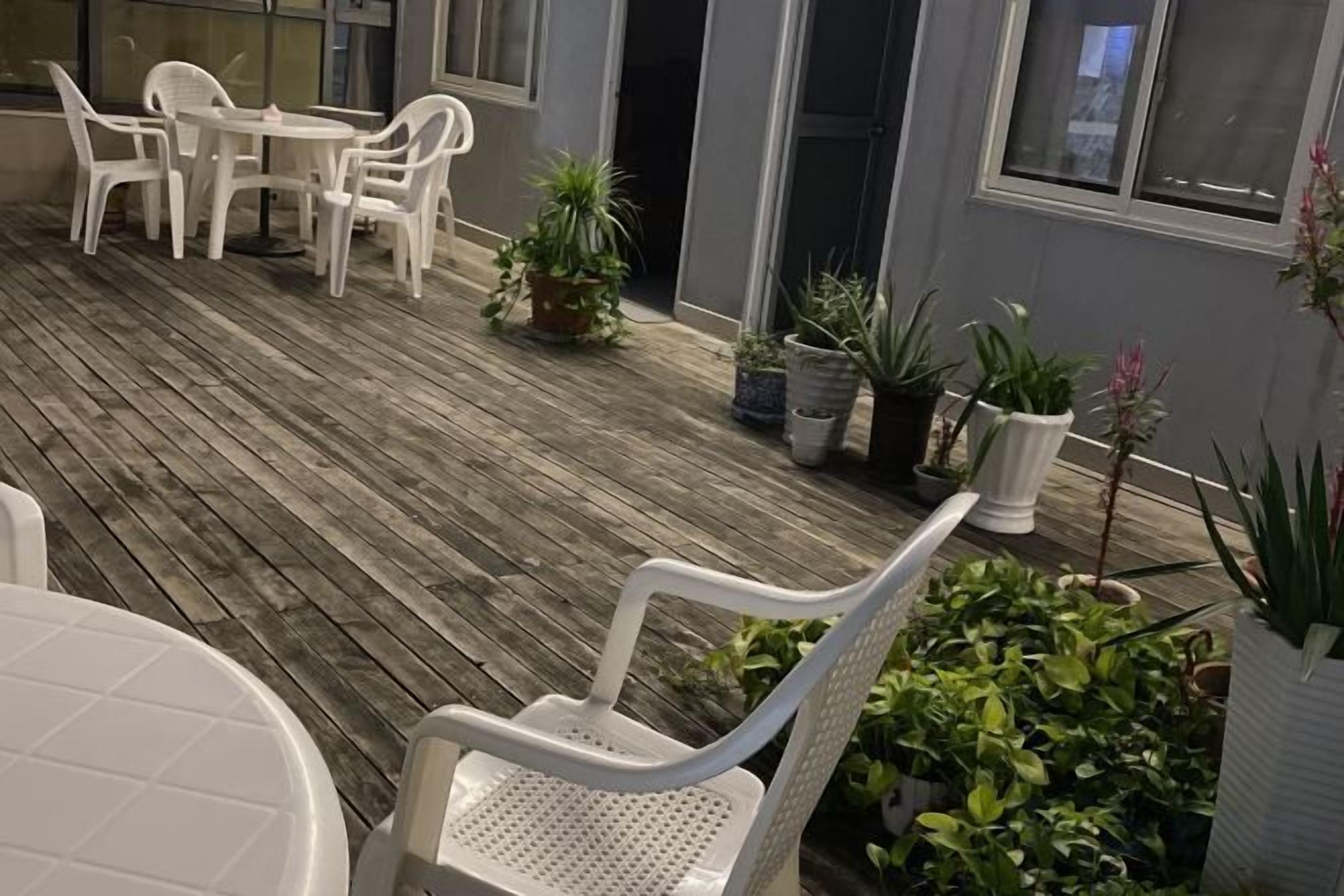 A wooden deck with outdoor seating and potted plants.