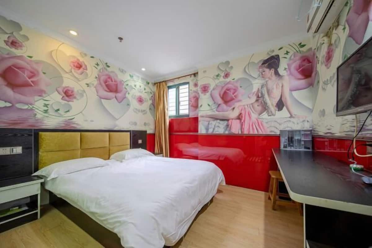Un dormitorio con cama, escritorio, silla y televisor.