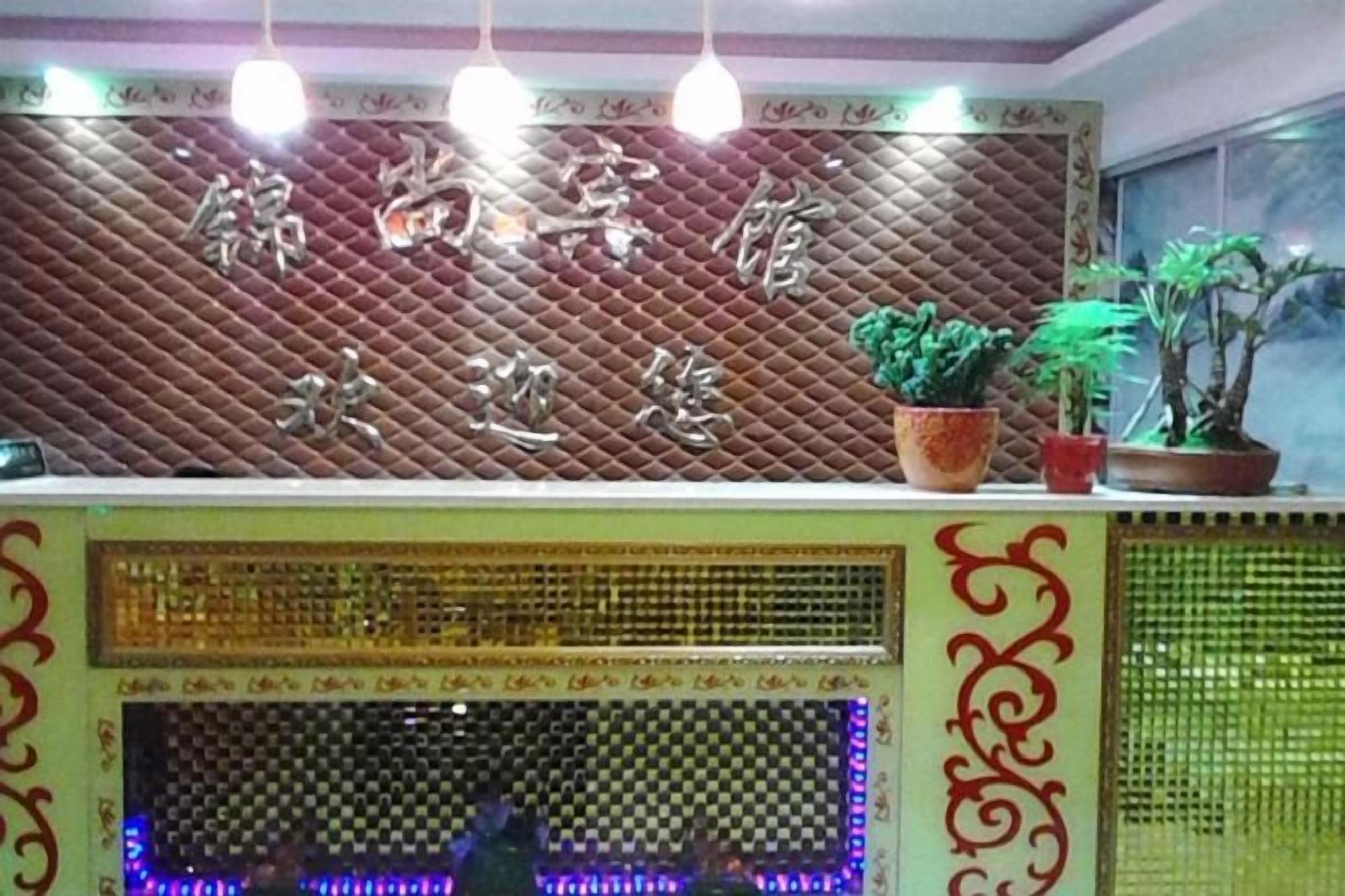 A reception area with a decorative wall, potted plants, and a patterned screen.