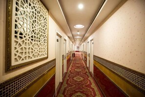 A long hallway with patterned walls and a red carpet, leading to a door at the end. - Jinshang Hostel (Shanghai)