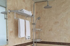 A bathroom with a shower, a towel rack with towels, and a tiled floor. - Jinshang Hostel (Shanghai)