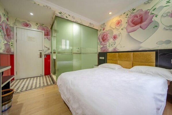 A bedroom with a bed, a wardrobe, and a shower area.
