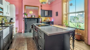 Een keuken met een centraal eiland, een groot raam en uitzicht op de omgeving.