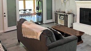Ein geräumiger Wohnbereich mit Deckenventilator, Kamin und Wandgestaltung mit Geweihen.