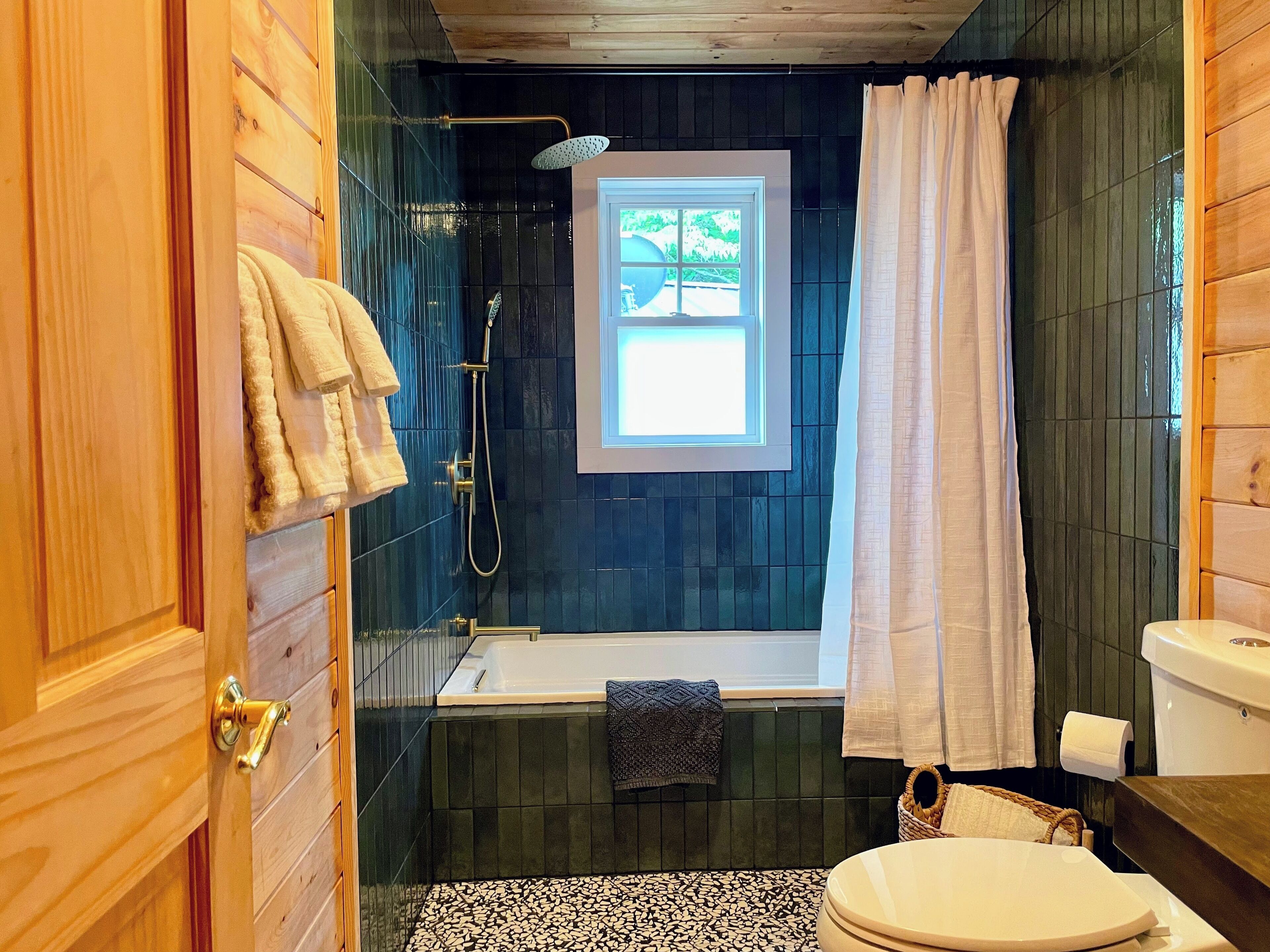 A bathroom with a bathtub, toilet, and shower.