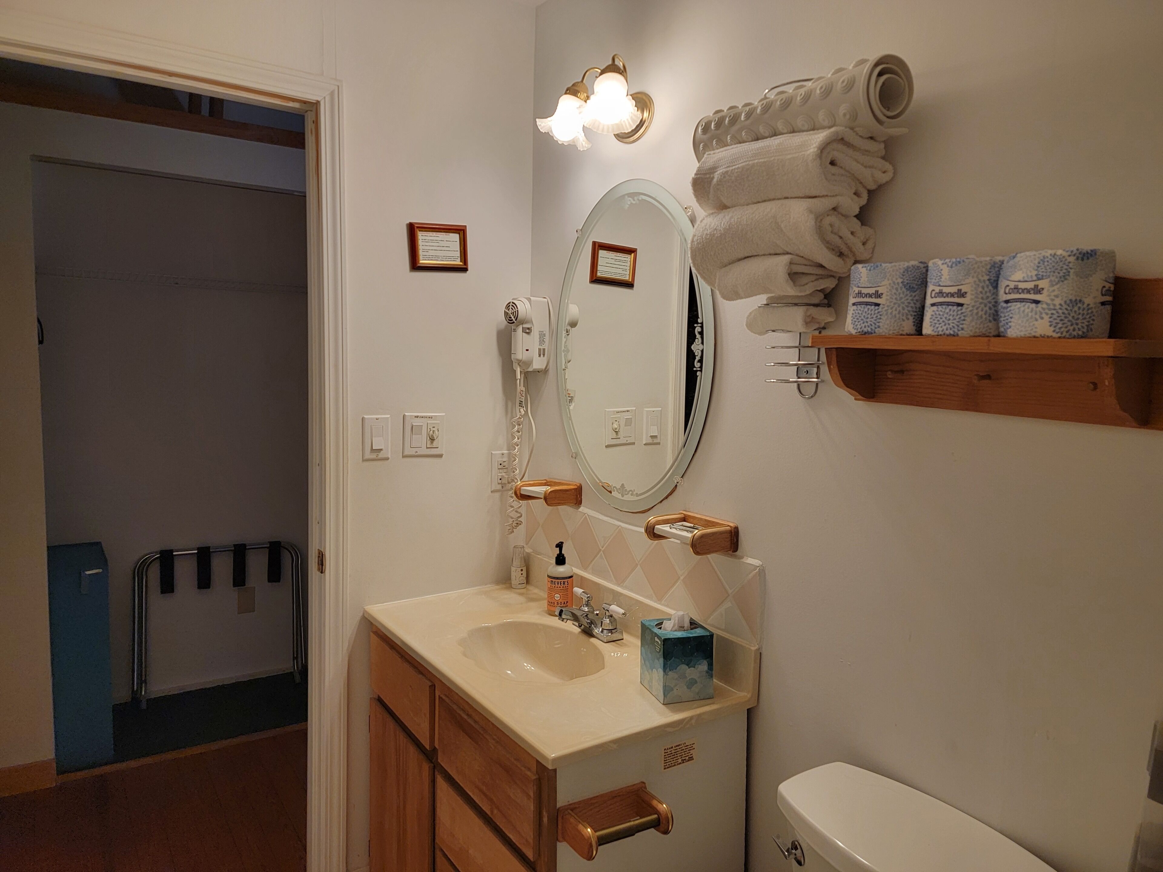 Une salle de bain équipée d’un lavabo, d’un miroir, d’un porte-serviettes et de toilettes.