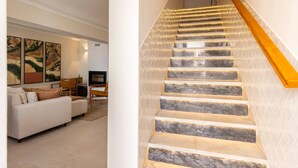 A staircase with marble steps and a wooden handrail, leading to an upper floor.