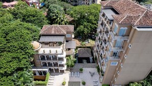 A multi-story residential building with a courtyard, balconies, and a swimming pool. - Tamarindo Beach Condo – 2BR Steps from Sea. (Tamarindo)