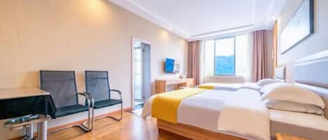 A hotel room with a bed, a desk, two chairs, a window, and a view of the outdoors.