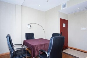 A conference room with a table, four chairs, a lamp, and a door.
