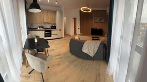 A modern apartment with a kitchen, dining area, and living room.