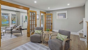 A spacious living area with a view of the outdoors, featuring a sofa, chairs, and a small table.