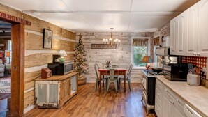 Una cucina rustica con pareti in legno, un tavolo da pranzo e un albero di Natale.
