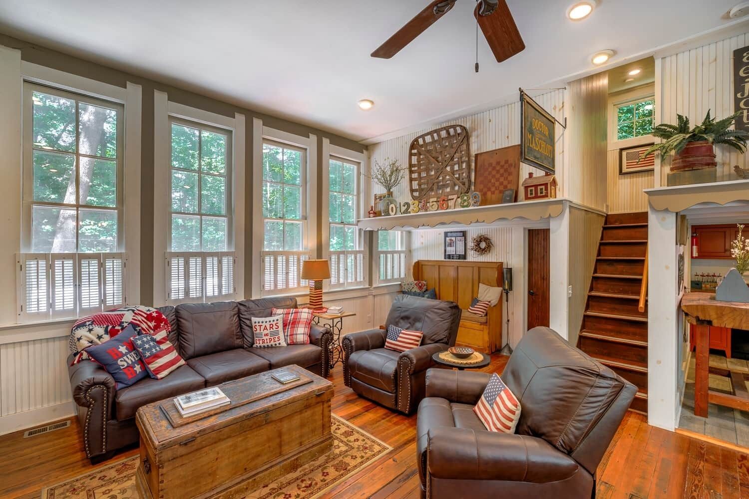 A spacious living room with leather sofas, a wooden coffee table, and a fireplace.
