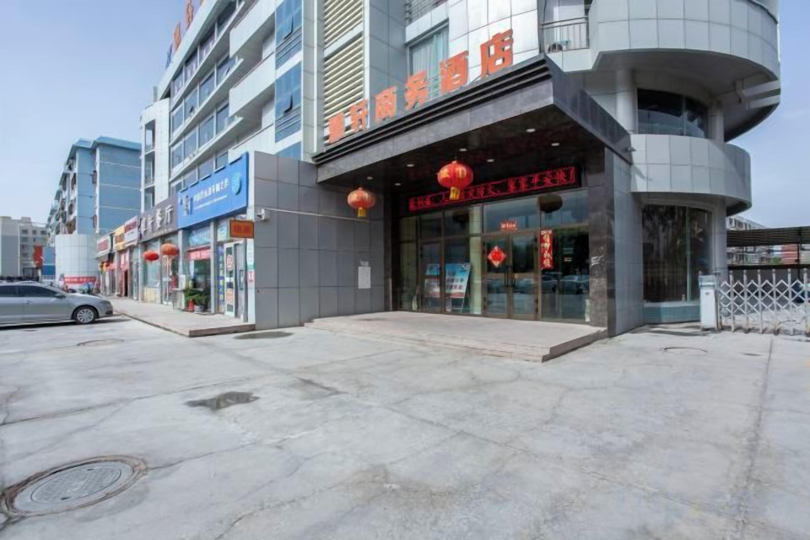 Un immeuble commercial abritant plusieurs commerces, notamment une pharmacie et un restaurant.