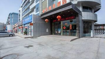 Un immeuble commercial abritant plusieurs commerces, notamment une pharmacie et un restaurant.