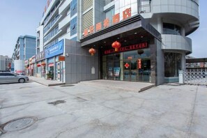Um edifício comercial com várias lojas, incluindo uma farmácia e um restaurante.