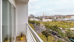 A balcony with a view of a cityscape, including a prominent building with a golden spire. - Stylish Stay in Lisbon-Scenic Views (Lisbon)