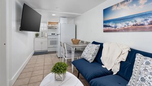 Un espacio habitable compacto con cocina, comedor y un amplio ventanal con vista al mar.