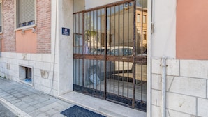 A building entrance with a metal gate, a small window with a towel hanging, and a sign indicating a family room.