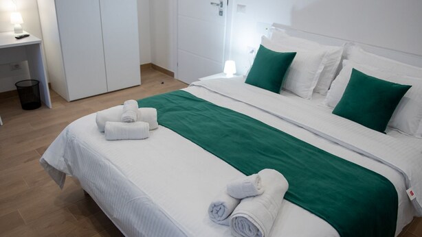 A hotel room with a bed, a desk, and a wardrobe. - Lovely Rooms - Room 3 by Rentbeat (Civitavecchia)