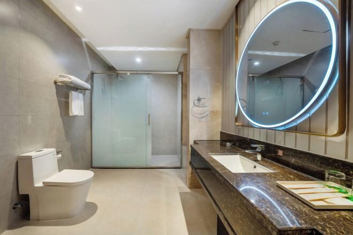 A modern bathroom with a toilet, sink, and shower.