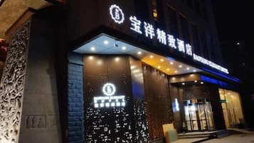 A hotel entrance with illuminated signage and a modern facade.